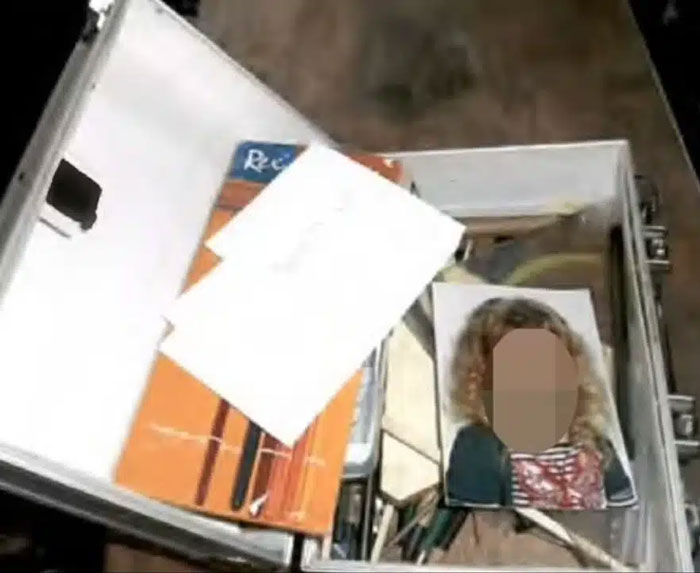 Photo of a metal case containing documents and a blurred image related to Madeleine McCann suspect investigation. Photo of a metal case containing documents and a blurred image related to Madeleine McCann suspect investigation.