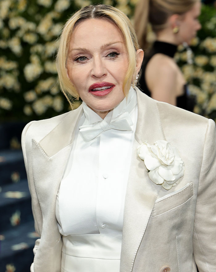 Madonna wearing a white suit with flower detail, fans notice a famous feature from her face is missing. Madonna wearing a white suit with flower detail, fans notice a famous feature from her face is missing.