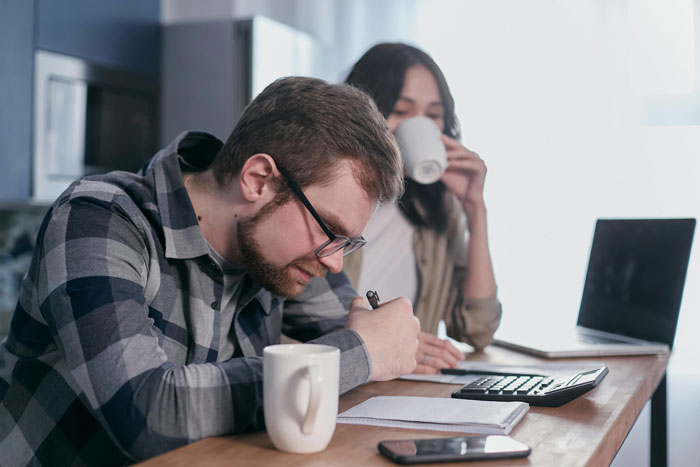 Teen kids calculating expenses at a table while mom drinks coffee, highlighting paying for their own junk food. Teen kids calculating expenses at a table while mom drinks coffee, highlighting paying for their own junk food.