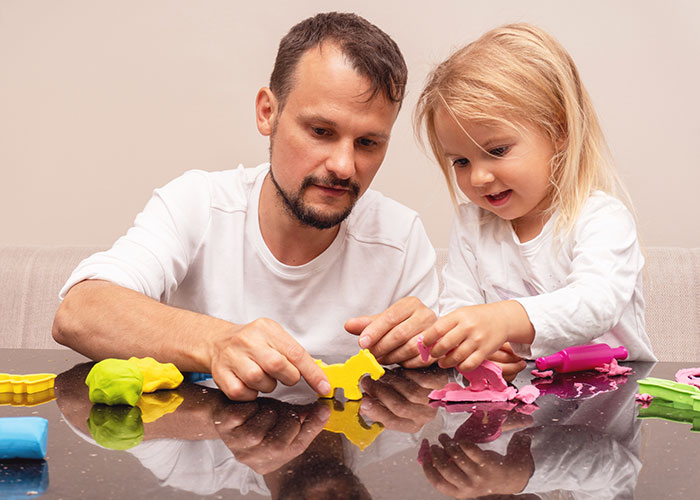 Man and child playing with colorful clay together, highlighting woman abandoning child with stranger roommate briefly. Man and child playing with colorful clay together, highlighting woman abandoning child with stranger roommate briefly.