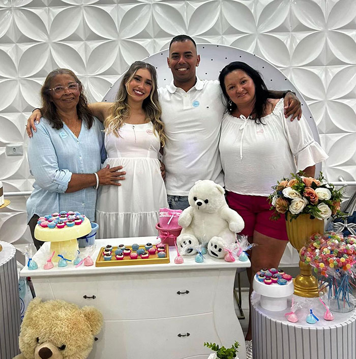 Family celebrating baby's gender reveal with cupcakes, teddy bears, and flowers in a decorated room. Family celebrating baby's gender reveal with cupcakes, teddy bears, and flowers in a decorated room.
