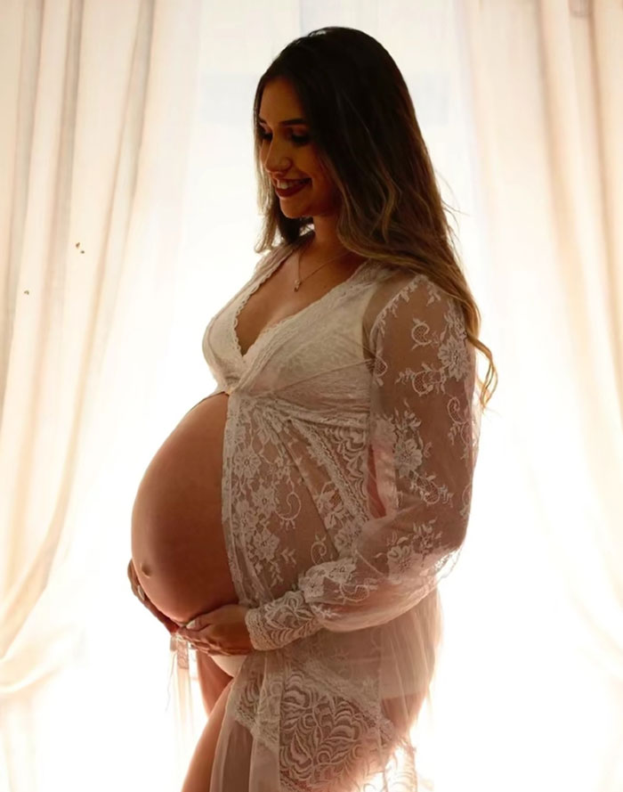 Pregnant woman smiling gently, wearing a lace robe, symbolizing baby gender reveal celebration and family debate context. Pregnant woman smiling gently, wearing a lace robe, symbolizing baby gender reveal celebration and family debate context.