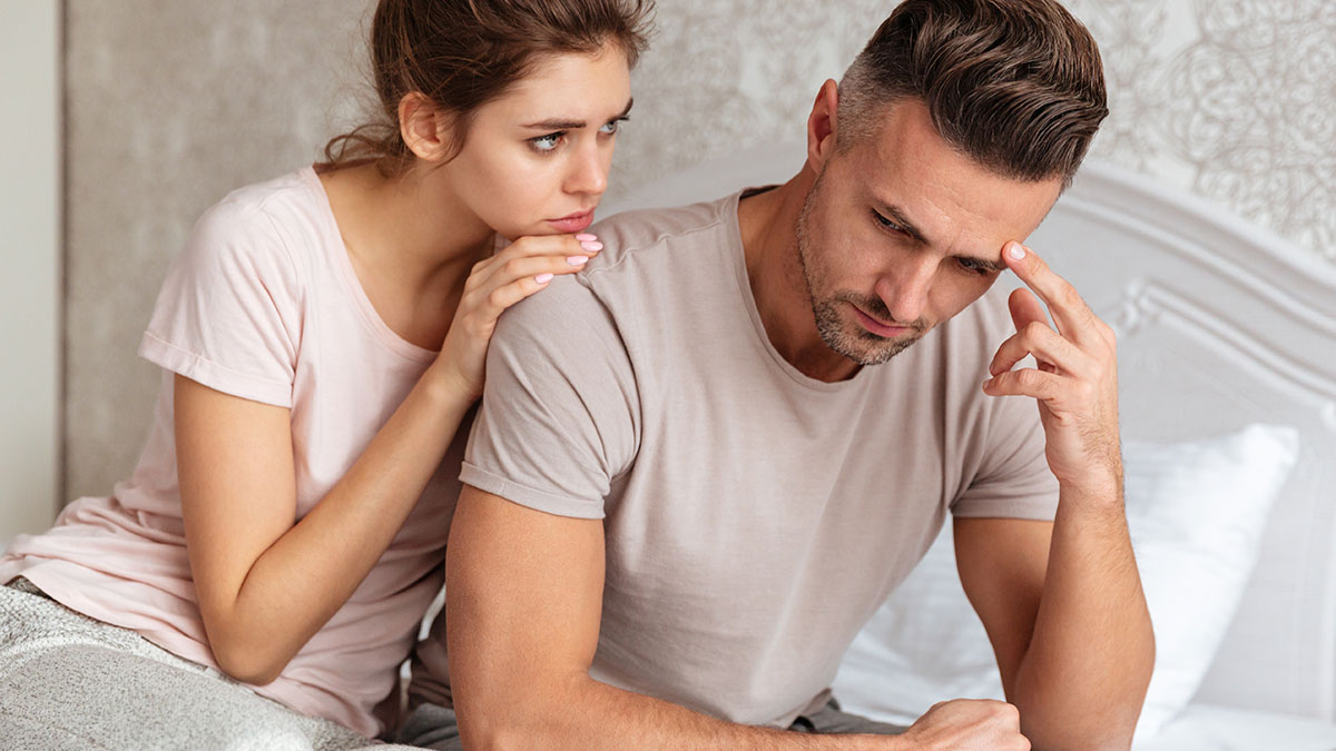 Man refusing to give up paid master bedroom looking upset while woman tries to comfort him on the bed.