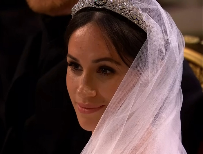 Meghan Markle wearing a tiara and veil at her royal wedding, with a calm and composed expression. Meghan Markle wearing a tiara and veil at her royal wedding, with a calm and composed expression.