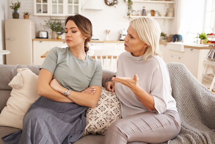 A woman calls herself mommy while having a serious conversation with a younger woman on a couch. A woman calls herself mommy while having a serious conversation with a younger woman on a couch.