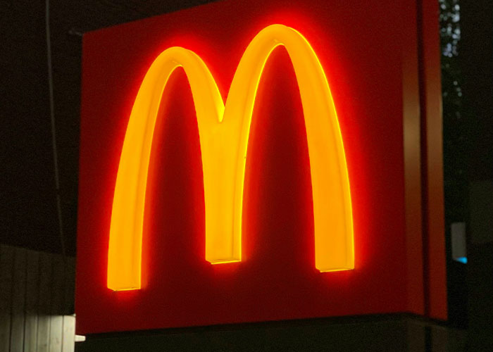 Neon McDonald's logo glowing at night, representing fast food related to mom refusing to leave kids with MIL. Neon McDonald's logo glowing at night, representing fast food related to mom refusing to leave kids with MIL.