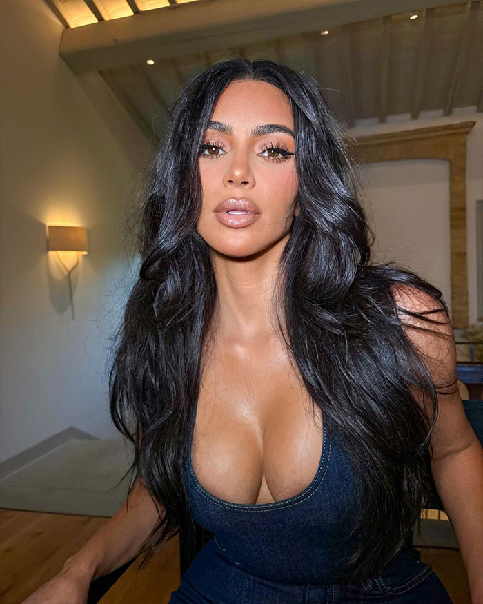 Kim Kardashian with long dark hair and makeup posing indoors, exploring the science behind the most beautiful woman in the world. Kim Kardashian with long dark hair and makeup posing indoors, exploring the science behind the most beautiful woman in the world.
