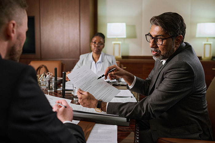 Lawyer in a suit explaining legal documents to a man during a consultation about raising a newborn alone and ex reappearing. Lawyer in a suit explaining legal documents to a man during a consultation about raising a newborn alone and ex reappearing.