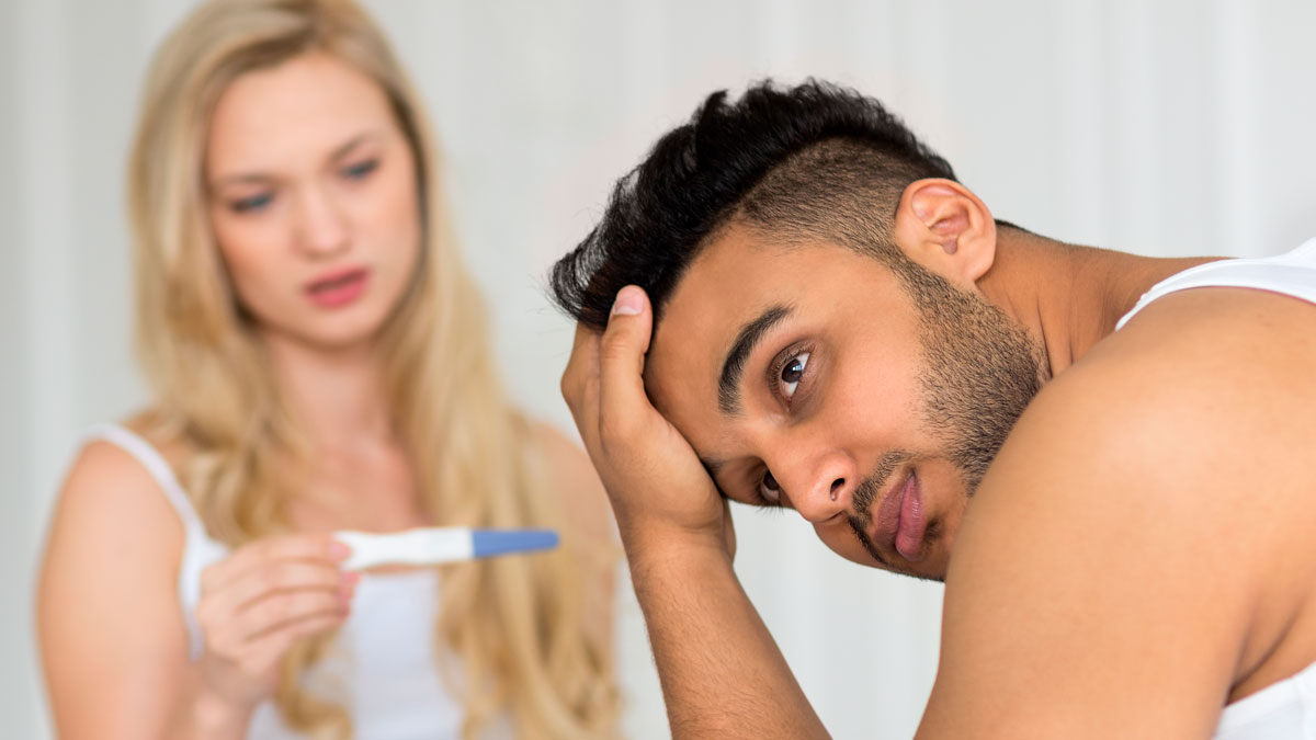 Man looks distressed while woman holds a pregnancy test, highlighting man raises newborn alone and forgiveness struggle.