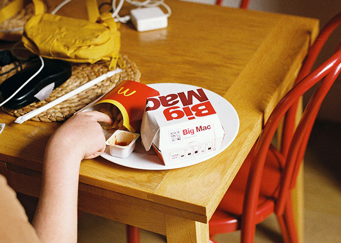 Child eating fast food with a Big Mac and fries on a plate, illustrating concerns about meals at MIL's house. Child eating fast food with a Big Mac and fries on a plate, illustrating concerns about meals at MIL's house.