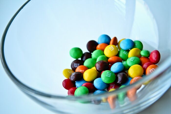 Colorful candy pieces in a clear glass bowl representing industry secrets behind closed doors in a vibrant display.
