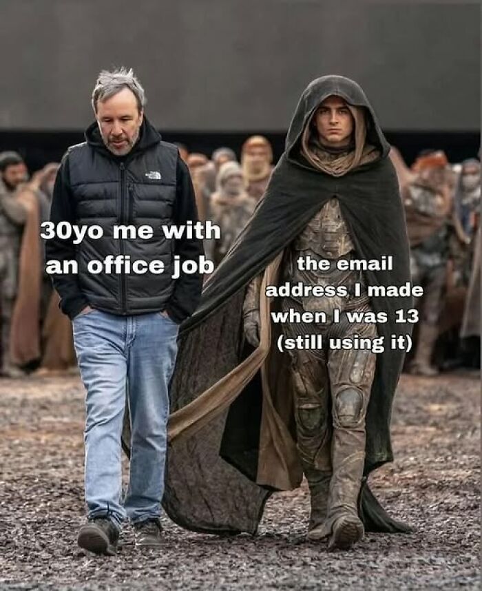 Man in casual clothes walking next to a cloaked figure, humorously comparing office job to old email address nostalgia meme.