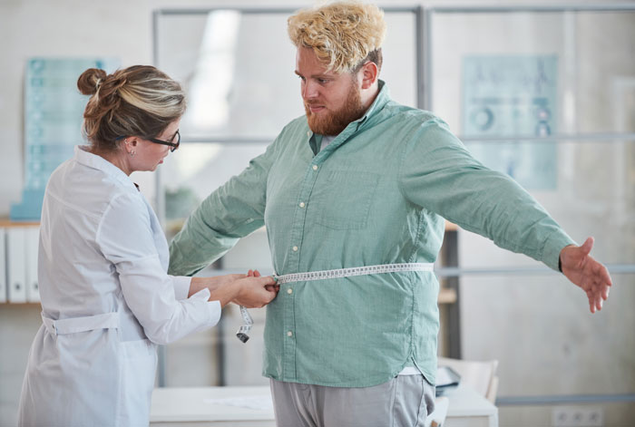 Healthcare professional measuring a man's waist, discussing effects of Ozempic as a popular diet medicine option. Healthcare professional measuring a man's waist, discussing effects of Ozempic as a popular diet medicine option.