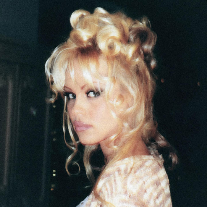Pamela Anderson with 90s glam makeup and voluminous curly blonde hair, showcasing a dramatic retro beauty look. Pamela Anderson with 90s glam makeup and voluminous curly blonde hair, showcasing a dramatic retro beauty look.