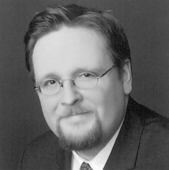 Man with glasses and beard in a black suit, representing the topic of children rescued after COVID paranoid parents trapped them indoors. Man with glasses and beard in a black suit, representing the topic of children rescued after COVID paranoid parents trapped them indoors.