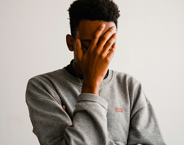 Young man upset and covering his face, expressing frustration related to partner strawberry allergy situation. Young man upset and covering his face, expressing frustration related to partner strawberry allergy situation.