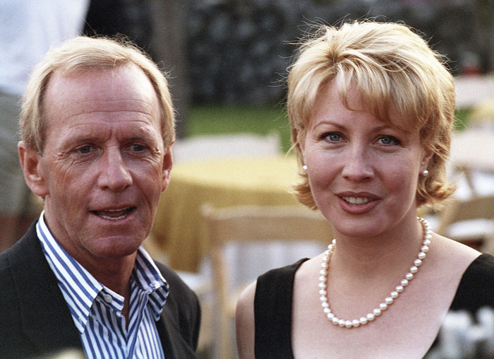 Paul Hogan, legendary Crocodile Dundee star, pictured with a woman at an outdoor event, smiling and dressed formally. Paul Hogan, legendary Crocodile Dundee star, pictured with a woman at an outdoor event, smiling and dressed formally.