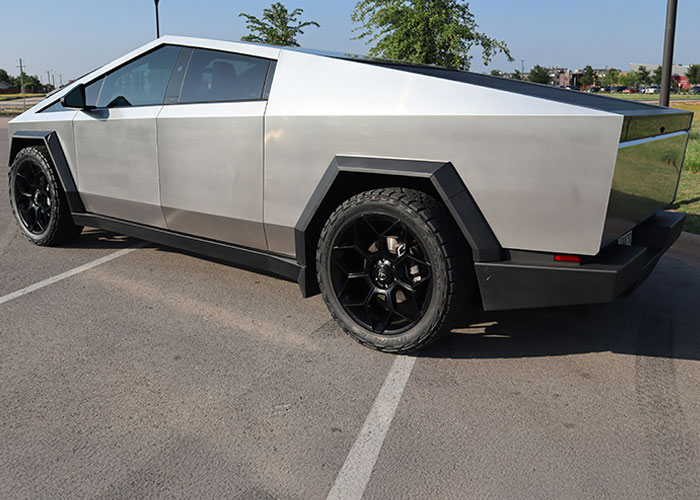 Silver futuristic truck parked on asphalt with sharp angles, highlighting the audacity of boss and late worker pay news. Silver futuristic truck parked on asphalt with sharp angles, highlighting the audacity of boss and late worker pay news.