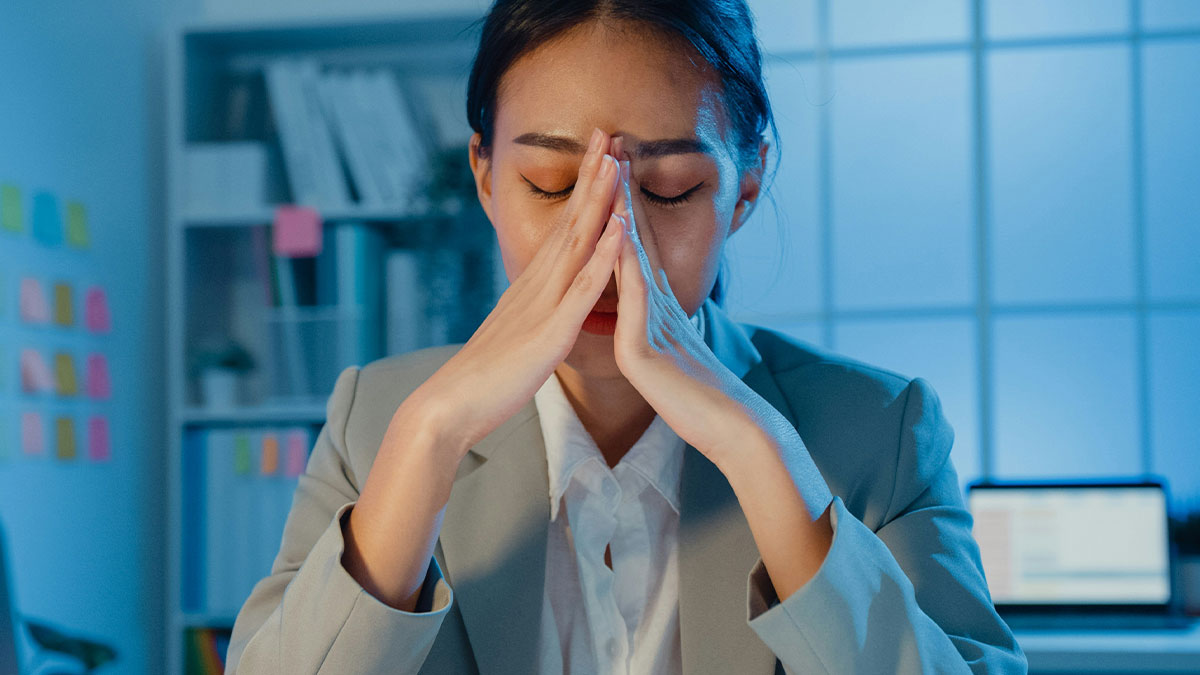 Stressed woman in office showing signs of workplace distress reflecting former employees revealing disturbing workplace secrets.