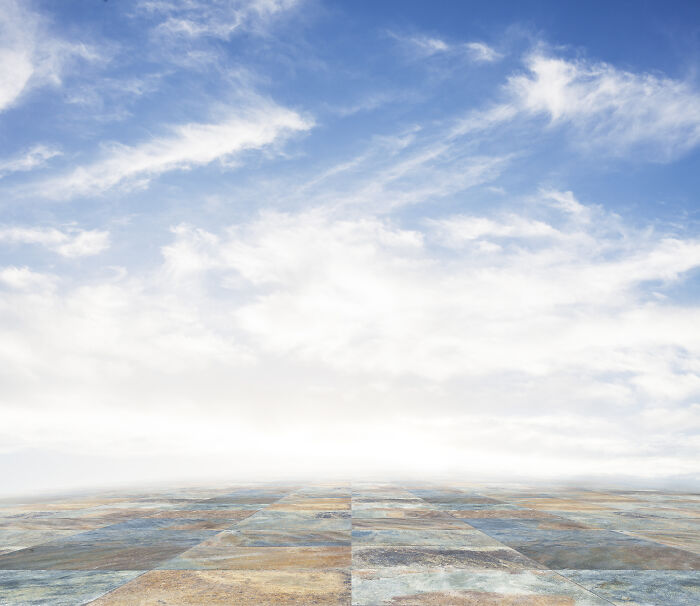 Open sky with clouds above a tiled floor, symbolizing the eerie and surreal feeling of time travel and resurrection.
