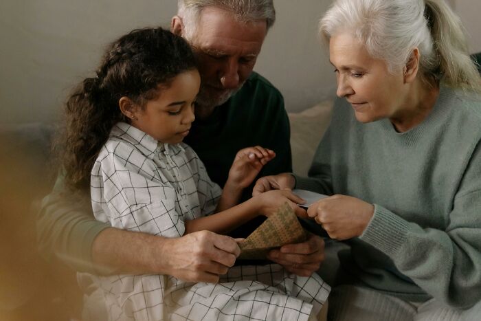 Older grandparents giving money to their granddaughter while feeling jealous of ex-in-laws' generosity. Older grandparents giving money to their granddaughter while feeling jealous of ex-in-laws' generosity.