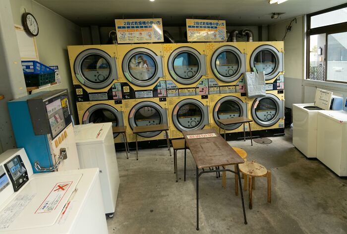 Laundromat interior with stacked dryers, washing machines, and seating, illustrating a wildest life blunders setting.