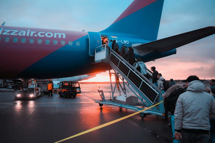 Passengers boarding a plane at sunset, illustrating common passenger habits that annoy flight attendants. Passengers boarding a plane at sunset, illustrating common passenger habits that annoy flight attendants.