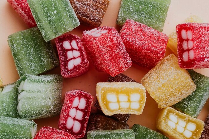 Colorful sugar-coated candies with tooth patterns, illustrating morally questionable behavior like piracy among netizens.