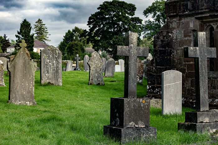 Old and weathered gravestones in a quiet cemetery under a cloudy sky symbolizing life blunders kept secret.