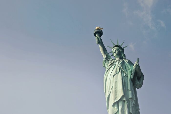 Statue of Liberty against a clear sky, symbolizing freedom and morally questionable things for netizens.