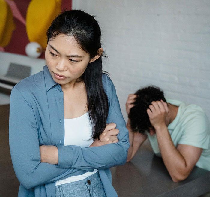 Frustrated ex fiance standing with arms crossed while Valentine day argument unfolds in apartment. Frustrated ex fiance standing with arms crossed while Valentine day argument unfolds in apartment.