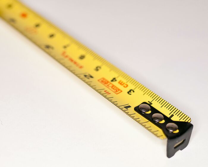 Yellow measuring tape extended on a white surface, symbolizing employees sharing the strangest recruiter comments.