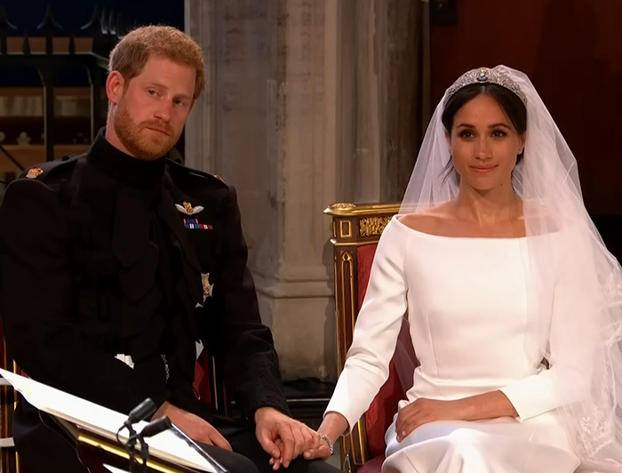 Prince Harry and Meghan Markle holding hands during their wedding ceremony, with Meghan in a bridal gown and veil. Prince Harry and Meghan Markle holding hands during their wedding ceremony, with Meghan in a bridal gown and veil.