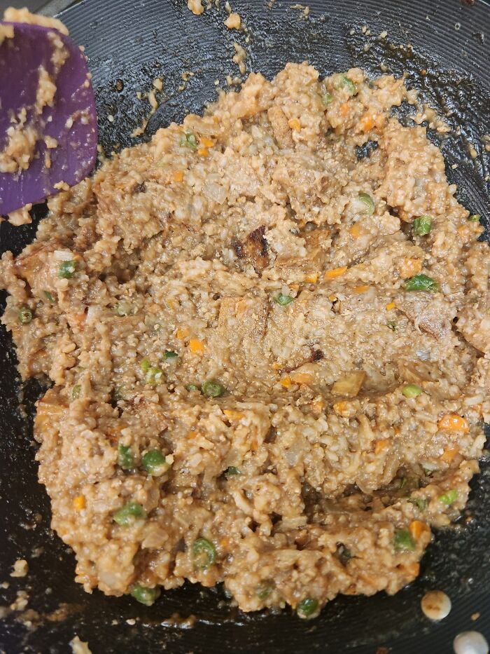 Burnt and clumpy cooking fail in a pan with mixed vegetables, illustrating a funny cooking accident gone wrong.