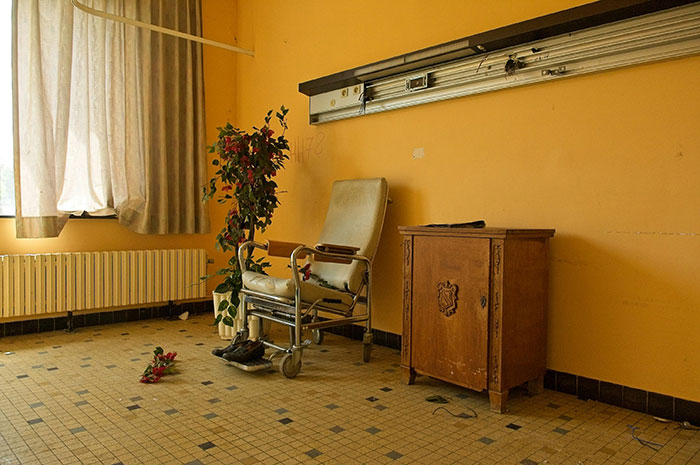 Abandoned room with old chair and cabinet, illustrating risky situations with no logical reason in unusual settings.
