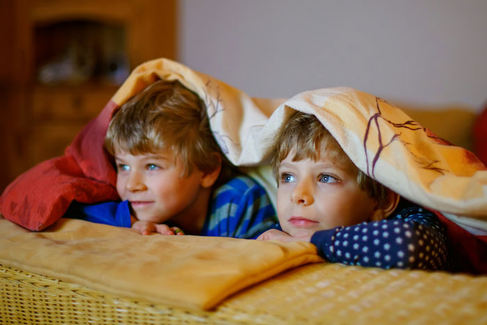 Two young children under a blanket looking thoughtful, illustrating neighbor demands babysit kids weekly responsibilities. Two young children under a blanket looking thoughtful, illustrating neighbor demands babysit kids weekly responsibilities.