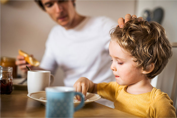 Father and child having breakfast together, illustrating dad’s stance on kids’ diet and custody challenges. Father and child having breakfast together, illustrating dad’s stance on kids’ diet and custody challenges.