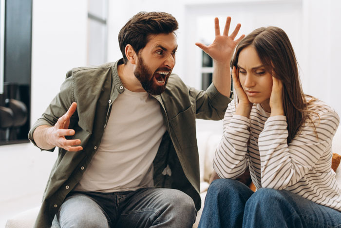 A man angrily shouting at a distressed woman in a home setting, illustrating conflict in a roommate vanishes with ex scenario.