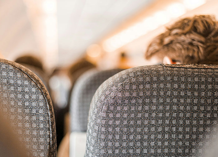 Woman thinks she's right to complain about plane passenger seated on airplane with blurred passengers ahead. Woman thinks she's right to complain about plane passenger seated on airplane with blurred passengers ahead.