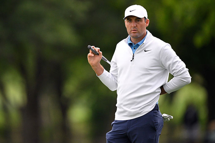Scottie Scheffler on the golf course wearing white Nike top, demonstrating the financial power of golf’s rising superstar.