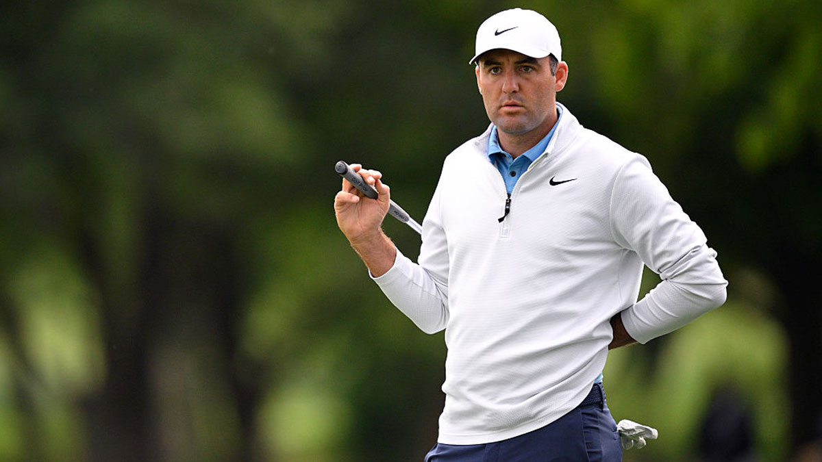 Scottie Scheffler on golf course holding putter, showcasing the financial power of golfu2019s most unlikely superstar.