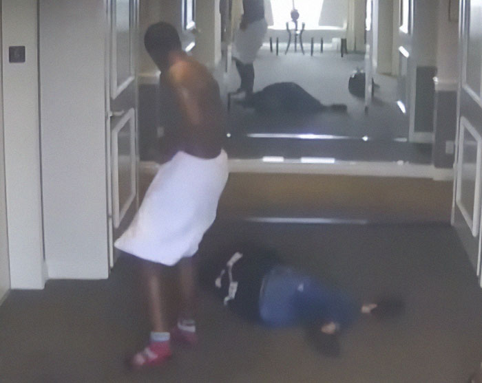 Man wrapped in towel preparing for event while another person lies on floor in hallway, photos showing Diddy preparation released Man wrapped in towel preparing for event while another person lies on floor in hallway, photos showing Diddy preparation released