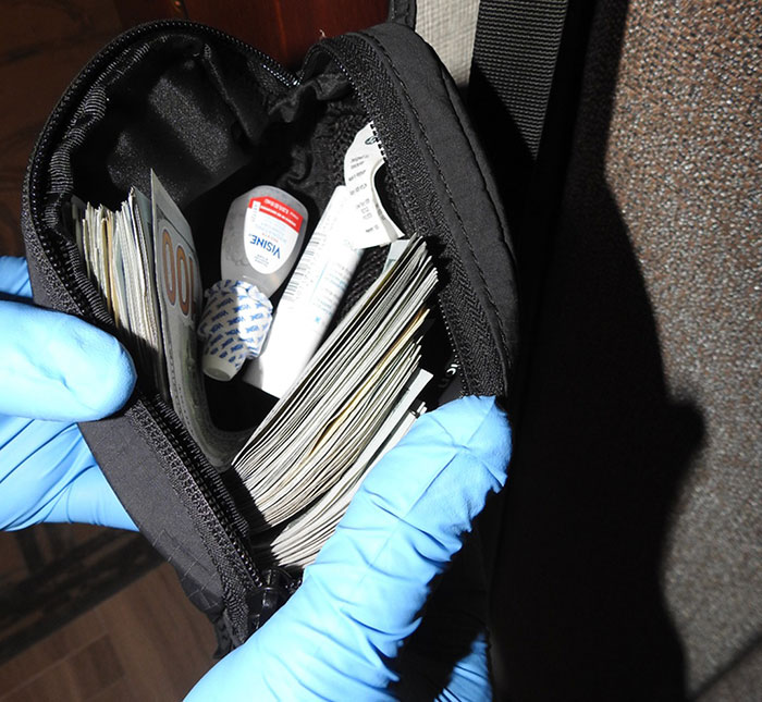 Gloved hands holding a small black bag filled with cash and medical supplies, showing preparation details for Freak Off. Gloved hands holding a small black bag filled with cash and medical supplies, showing preparation details for Freak Off.