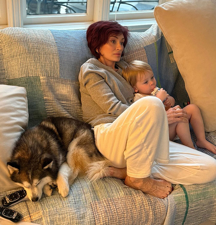 Sharon Osbourne sitting on a couch with a child and a dog, showcasing her appearance after using Ozempic for weight control. Sharon Osbourne sitting on a couch with a child and a dog, showcasing her appearance after using Ozempic for weight control.