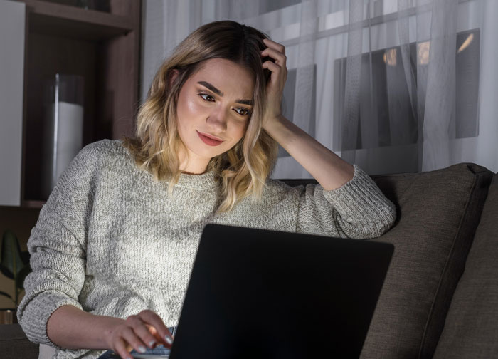 Teen girl looking concerned while using laptop at home, reflecting on girl’s 11th birthday issues with relatives demands.