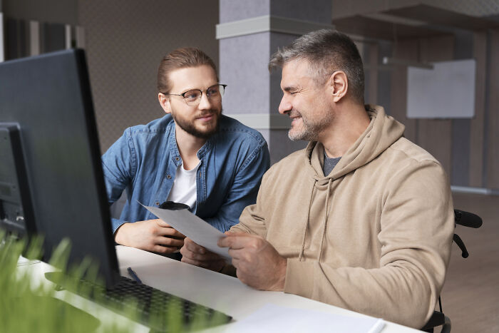 Two tech guys discussing weird or disturbing findings while fixing a customer’s computer in an office setting.