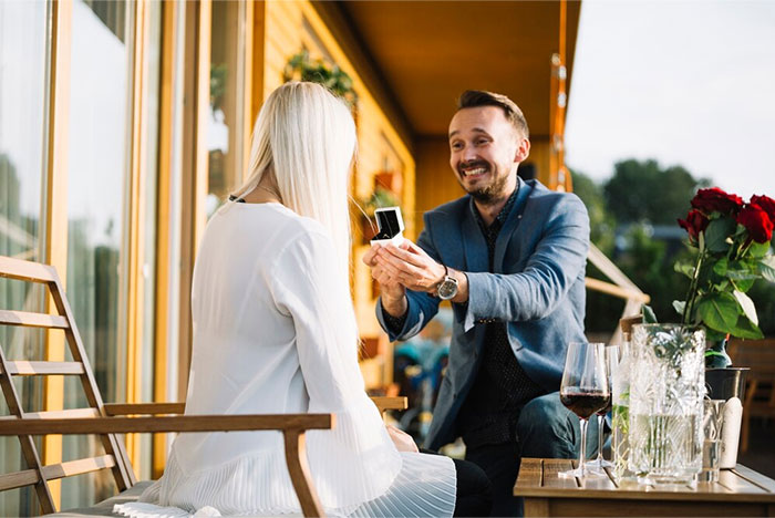 Man proposing to woman outdoors with engagement ring, reflecting the topic of boyfriend's proposal at wedding. Man proposing to woman outdoors with engagement ring, reflecting the topic of boyfriend's proposal at wedding.