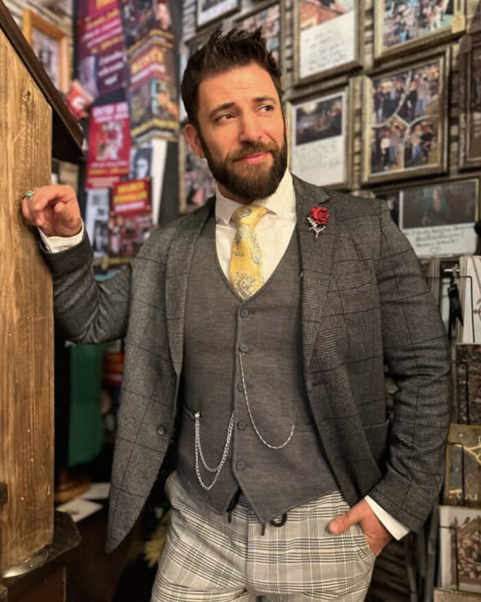 Actor who played Viktor Krum from Harry Potter in a checkered suit posing indoors with framed photos on the wall behind him. Actor who played Viktor Krum from Harry Potter in a checkered suit posing indoors with framed photos on the wall behind him.