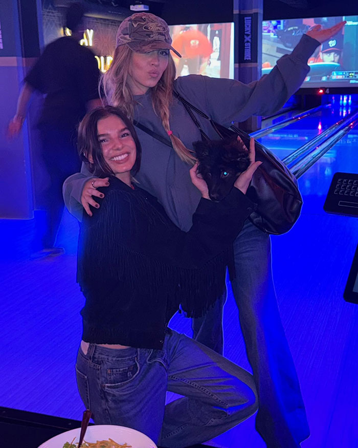 Two women posing with a small black puppy indoors, capturing a moment linked to Sydney Sweeney slammed for parading puppy. Two women posing with a small black puppy indoors, capturing a moment linked to Sydney Sweeney slammed for parading puppy.