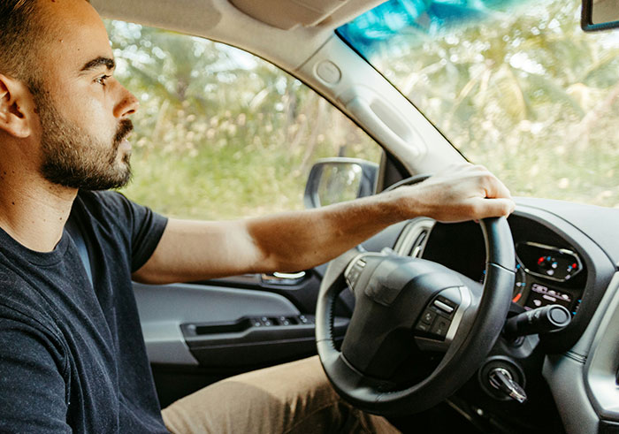 Man driving a car with focus and concern, illustrating one of the things that could completely destroy people's lives in seconds.